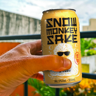 A hand holding a can of Snow Monkey Sake - Lemon & Yuzu